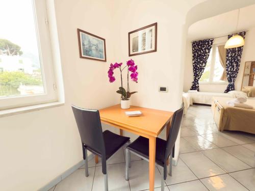 a dining room with a wooden table and chairs at Excelsior Mare Suite in Ischia