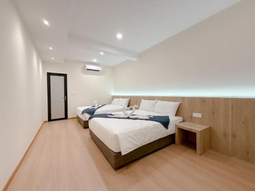 a bedroom with two beds and a table at Resandau Stay Ipoh - Nearby Ipoh Town - Private Car Park and Lift - Whole unit & Coliving in Ipoh