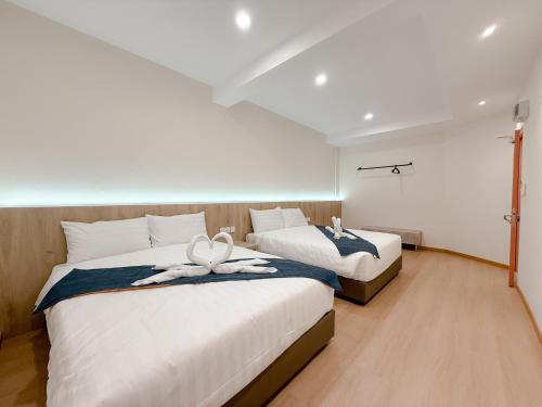 a bedroom with two beds with towels on them at Resandau Stay Ipoh - Nearby Ipoh Town - Private Car Park and Lift - Whole unit & Coliving in Ipoh