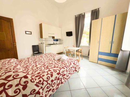 a bedroom with a bed with a red and white blanket at Excelsior Mare Suite in Ischia