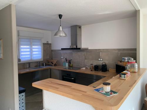 une cuisine avec un comptoir en bois dans une pièce dans l'établissement La Petite Villa du Soleil, à Lavalette