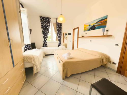 a hotel room with two beds and a chair at Excelsior Mare Suite in Ischia