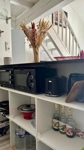 une étagère de cuisine avec un micro-ondes et un escalier dans l'établissement Loft Bohème Placette, à Nîmes