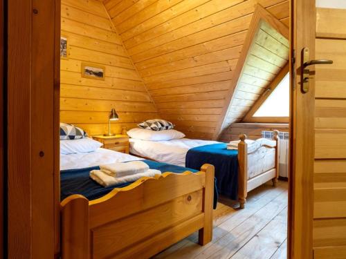 a bedroom with two beds in a attic at GLICZAROWA OSADA, Chata 18 osób, Domek 8 osób NA WYŁĄCZNOŚĆ, 8 sypialni z łazienkami, spokój, przyroda, wyjątkowe miejsce in Gliczarów