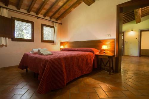a bedroom with a large bed with a red blanket at Agriturismo Monacianello - Fontebelvedere wine estate in Ponte A Bozzone