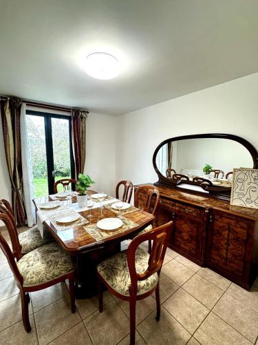 une salle à manger avec une table et un miroir dans l'établissement Maison familiale Vintage à Meaux, à Meaux
