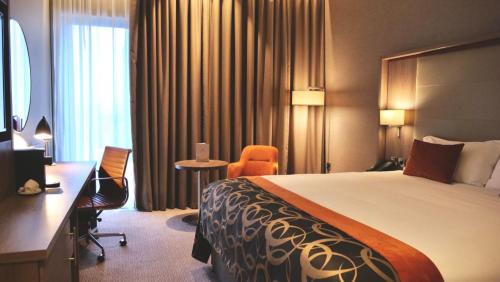 バーミンガムにあるClayton Hotel Birminghamのベッドと机があるホテルの部屋