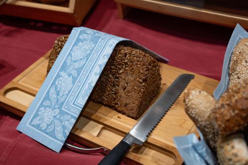 a loaf of bread on a cutting board with a knife at Der Alpenhof Maria Alm in Maria Alm am Steinernen Meer