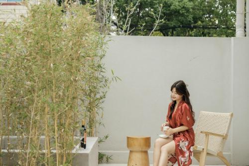 a woman in a red dress sitting on a chair at My Home in Shanghai