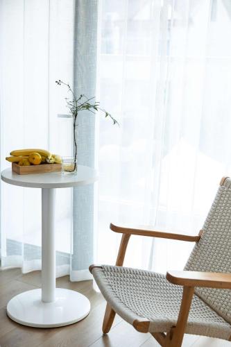 a table with a bowl of bananas and a chair at My Home in Shanghai