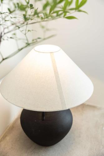 a white lamp sitting on top of a black vase at My Home in Shanghai
