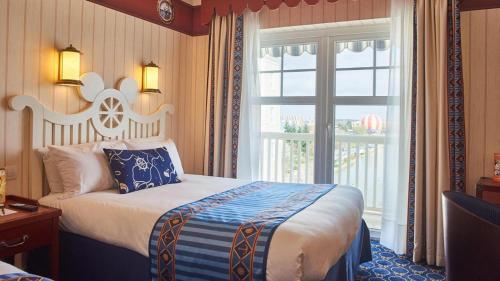 a hotel room with a bed and a window at Disney Newport Bay Club in Chessy