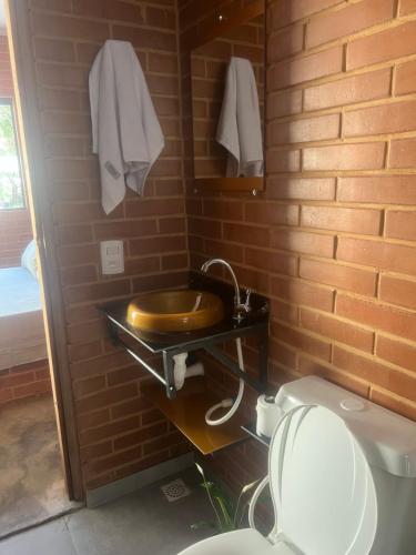 a bathroom with a wooden sink and a toilet at Flats Ribeiro in Alto Paraíso de Goiás