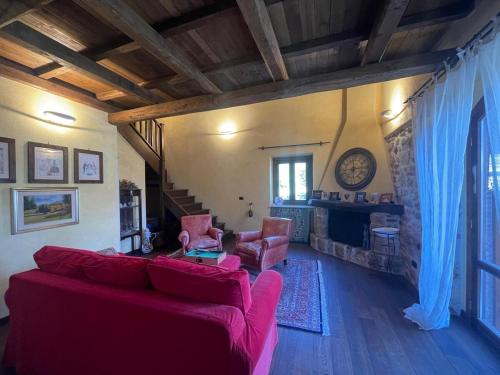 a living room with a red couch and a fireplace at Il Mulino esclusivo soggiorno in Colle