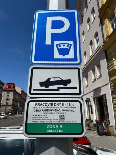 a parking sign on a pole with a car on it at Hotel Palác in Olomouc
