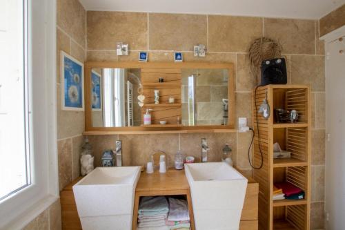 a bathroom with two sinks and a mirror at La petite barque in Saint-Julien-de-Lampon