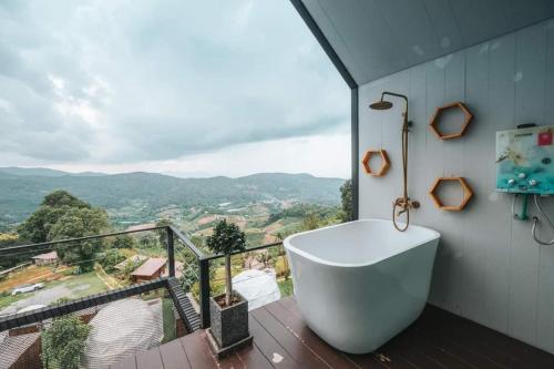 a bathroom with a bath tub on a balcony at ม่อนเหนือโฮมสเตย์ Monnuea Homestay in Mon Jam