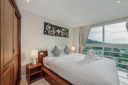 Ban KataにあるC196 Condo 1BR Sea View & 5 Min to Beachのベッドが2つと大きな窓がある寝室