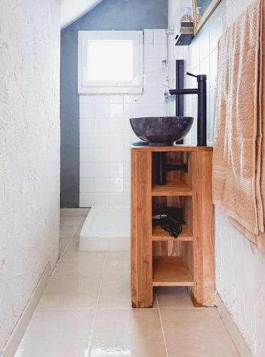 La salle de bains est pourvue d'un lavabo en bois. dans l'établissement Gîte Au Coeur de l 'Alllier, à Droiturier