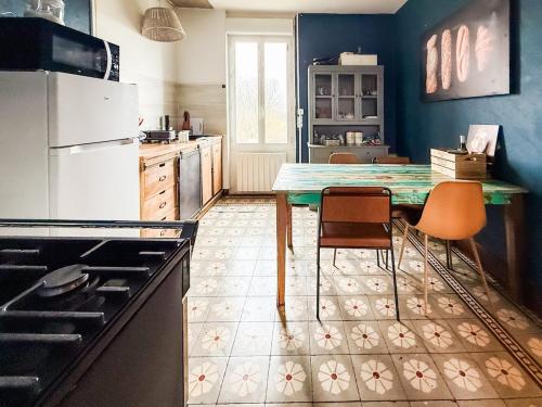 - une cuisine avec une table et deux chaises dans l'établissement Gîte Au Coeur de l 'Alllier, à Droiturier