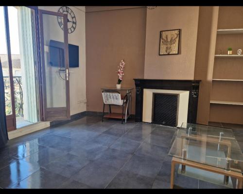 un salon avec une cheminée et une table dans l'établissement Le Petit Servian, à Servian