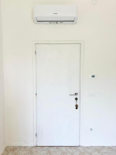 a white door in a white room with a ceiling at Ethos Guest House in Quarto dʼAltino