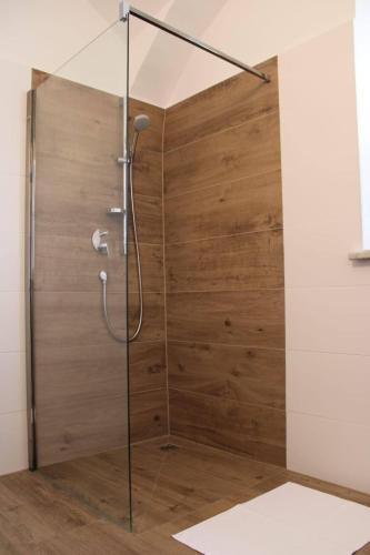 eine Duschkabine mit einer Holzwand in der Unterkunft Apartment Peer 