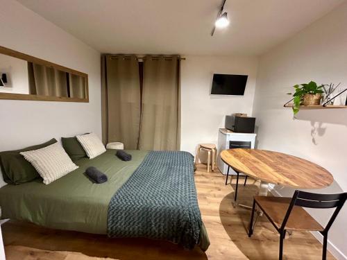 une chambre avec un lit et une table en bois dans l'établissement Charmant logement tout confort, à Bernex