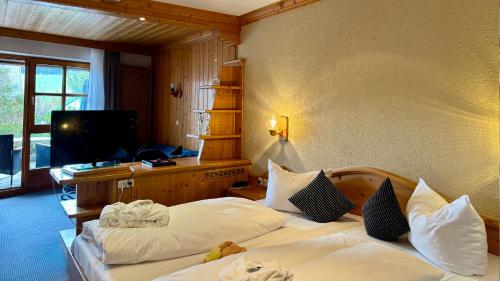 a hotel room with two beds and a flat screen tv at Wellness Hotel Bayerischer Hof in Rimbach