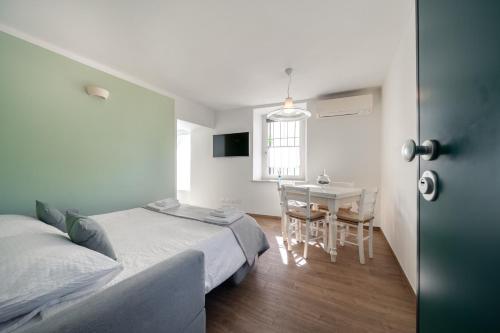 a bedroom with a bed and a table with a chair at Appartamenti Alla Lanterna in Costermano sul Garda