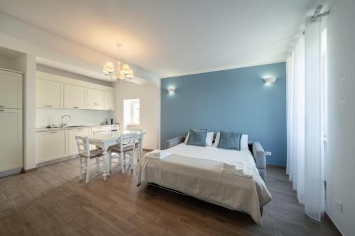 a bedroom with a bed and a table and a kitchen at Appartamenti Alla Lanterna in Costermano sul Garda