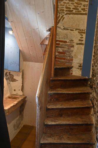 - un escalier dans une pièce dotée d'un mur en briques dans l'établissement Maison coeur de ville - 8 couchages - Oléron, à Saint-Georges-dʼOléron