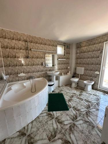 a bathroom with two sinks and a tub and two toilets at Pensiunea DEDU in Buşteni