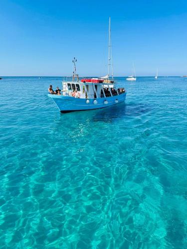 a blue boat floating in the blue water at CASA ELAIO - immersa negli ulivi con vista sul mare Ionio in Marina San Gregorio