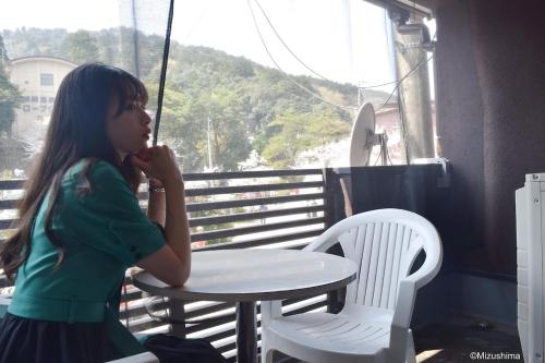 a young girl sitting at a table in front of a window at BookStore iChi in Toyooka