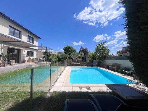 une piscine dans une cour à côté d'une maison dans l'établissement Belle villa familiale avec piscine, à Teyran