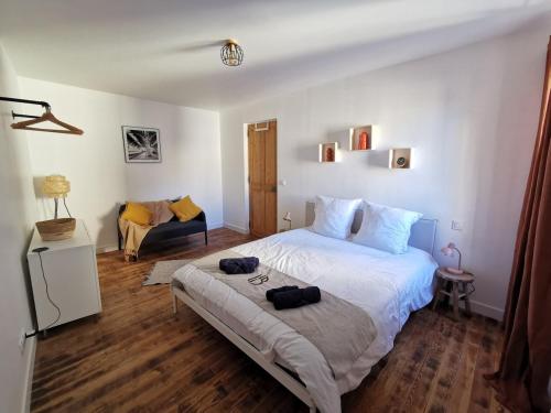 une chambre avec un grand lit et une chaise dans l'établissement House heart of a Provençal village, à Barbentane