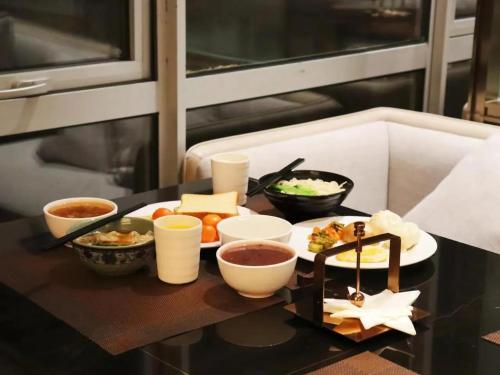 a tray of food on a table with bowls of food at Shanghai Hongqiao Heyitang Hotel Beixinjing Subway Station Branch in Shanghai