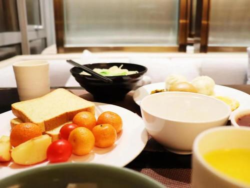 a table with a plate of bread and vegetables on it at Shanghai Hongqiao Heyitang Hotel Beixinjing Subway Station Branch in Shanghai
