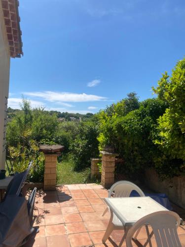 un patio avec une table, des chaises et des arbres dans l'établissement Chambre, terrasse , salle de bains toilettes privé, à Valensole