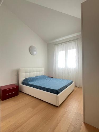 a white bedroom with a bed and a window at Villa Greta in Lido di Jesolo