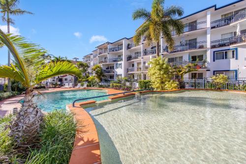 a swimming pool in front of a apartment building at Blue Water Bay Luxury Villas - Southport in Gold Coast