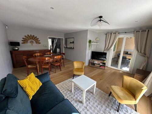 a living room with a couch and a table and chairs at Le Cocon Familial du Sud - Jacuzzi, Wi-Fi, air conditioning in Sauvian