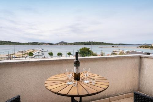 a bottle of wine sitting on a table with two glasses at Spacious Apartments by the Sea in Srima, Vodice in Srima
