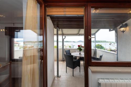 a room with a balcony with a table and chairs at Spacious Apartments by the Sea in Srima, Vodice in Srima