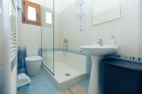 a bathroom with a toilet and a sink and a shower at Friend House in Néa Péramos