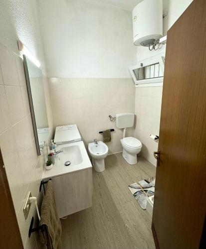 a white bathroom with a toilet and a sink at Casa Nala Costa Rei in Costa Rei