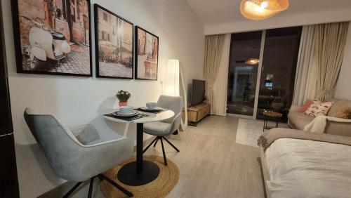 a living room with a bed and a table and chairs at Deluxe Studio - Stylish & Cosy in Luma22 in Dubai