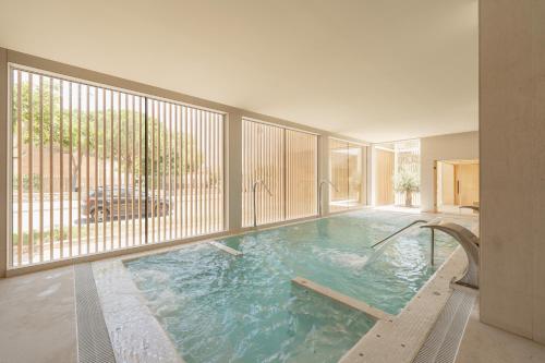 a swimming pool in a house with a large window at RH Silene Hotel & Spa 4 Sup in Castellón de la Plana