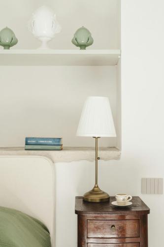 a lamp on a table next to a bed at La Canonica Suites in Cannole